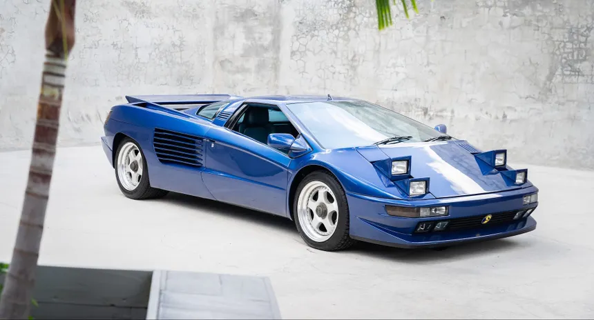A blue Cizeta V16T showing its iconic quad pop-up headlights and aggressive Gandini wedge design.