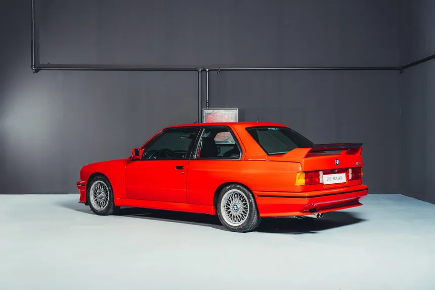 A lineup of BMW M3 generations from the E30 to the G80, highlighting the shift from track-bred lightness to modern luxury heft.