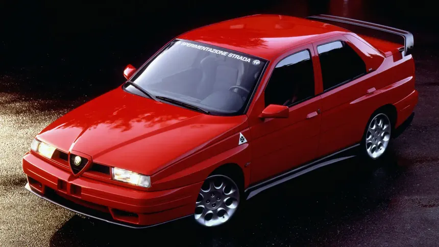 Red Alfa Romeo 155 Q4 front three-quarter view showing Series 1 bodywork alloy wheels and Alfa Romeo grille shield

