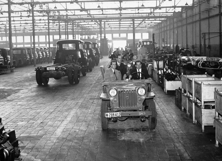 Eduardo Barreiros in a 1950s industrial workshop surrounded by diesel engines and tools, dramatic black and white lighting reflecting the determination of a mechanic fighting against the system