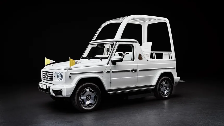 White papal vehicle with elevated bulletproof glass dome on raised platform, surrounded by crowd, dramatic ceremonial lighting