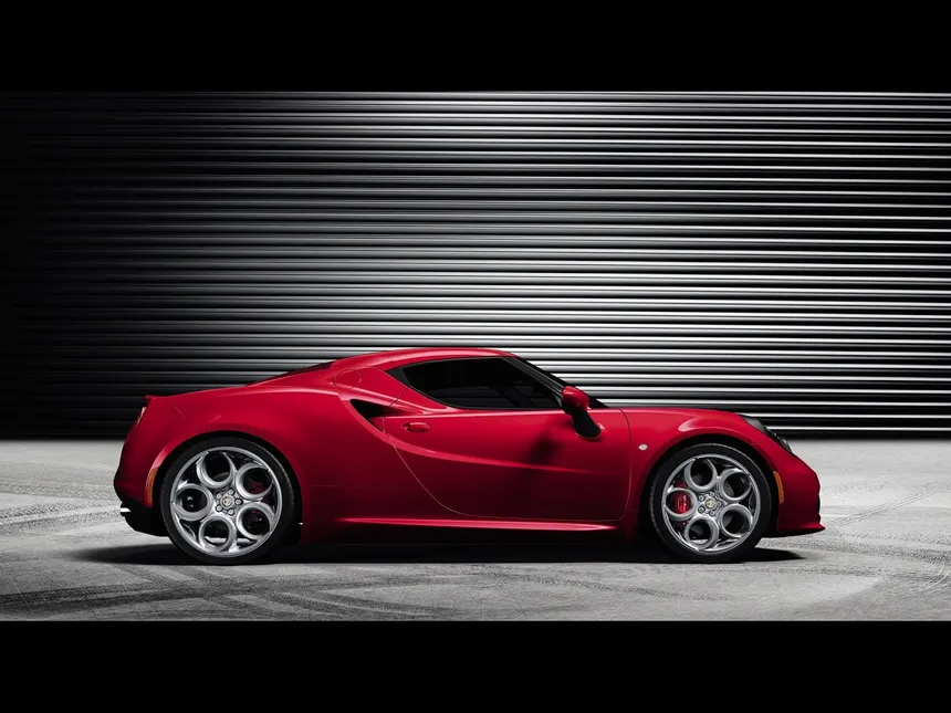 Alfa Romeo 4C coupe in Rosso Alfa from three-quarter front angle showing mid-engine silhouette
