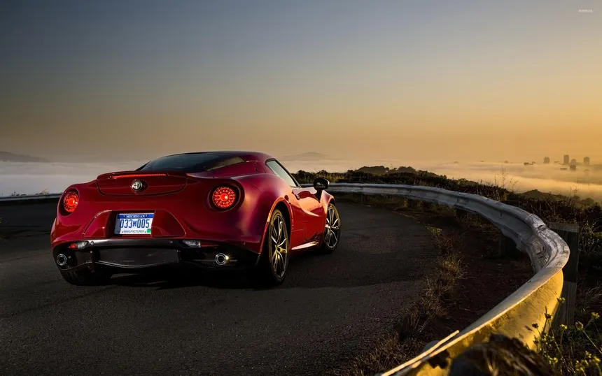 Alfa Romeo 4C coupe in Rosso Alfa from three-quarter front angle showing mid-engine silhouette