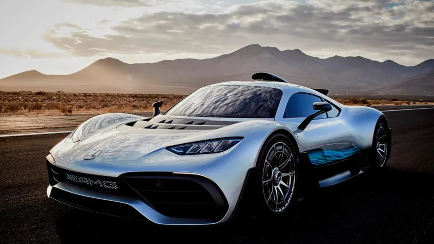 Mercedes-AMG One hypercar in silver metallic at speed on a race track at sunset with rear wing deployed