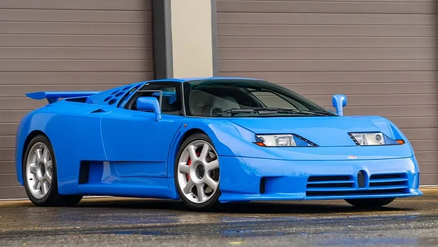 Bugatti EB110 GT azul con puertas tijera abiertas en la fábrica de Campogalliano