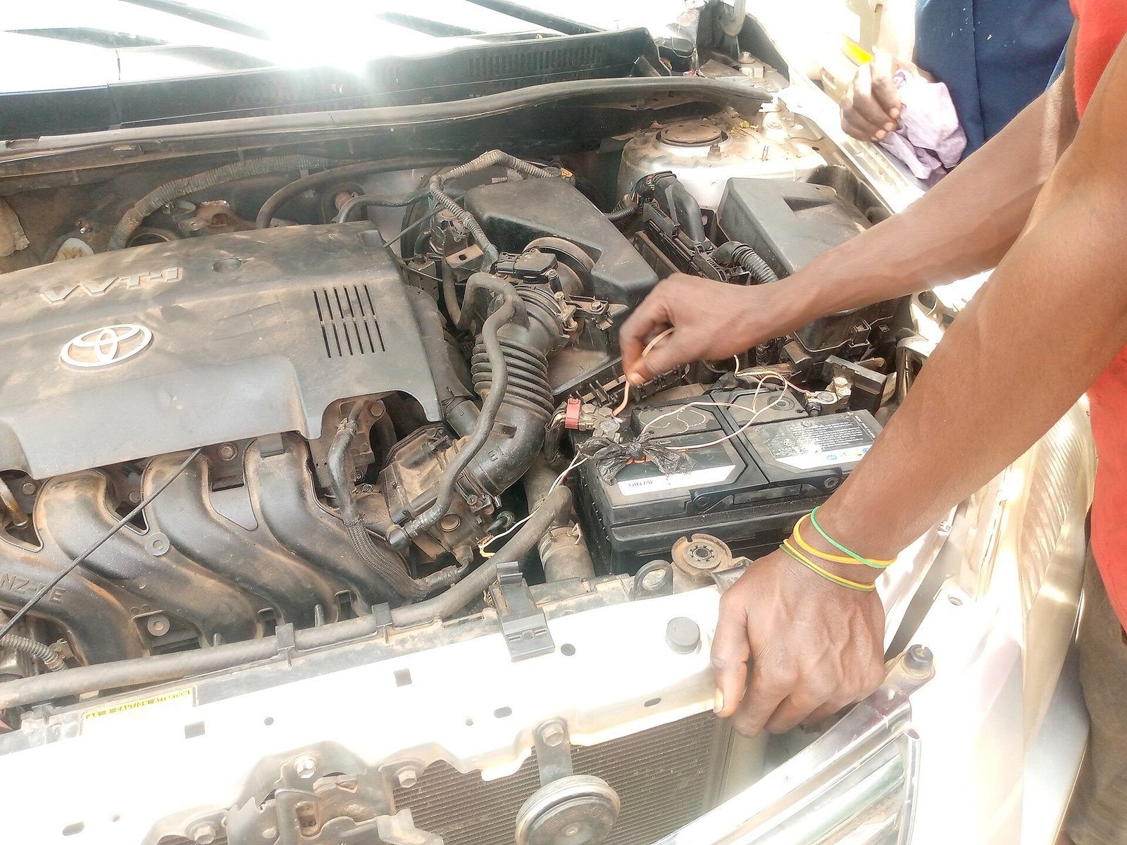 Meccanico che controlla la batteria nel vano motore