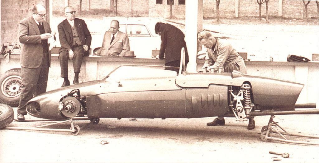 Carlo Chiti junto al morro del Ferrari 156 F1 en Módena en marzo de 1961, con Enzo Ferrari sentado al fondo