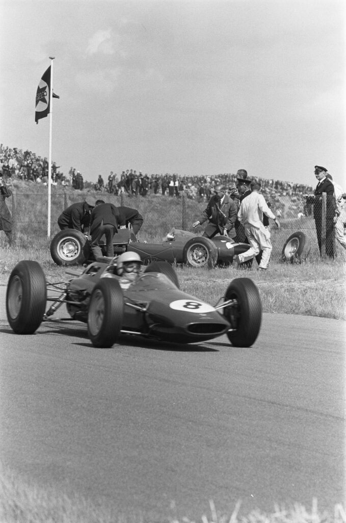 1963 Dutch Grand Prix at Zandvoort: Trevor Taylor's Lotus passes Phil Hill's stranded ATS and its mechanics