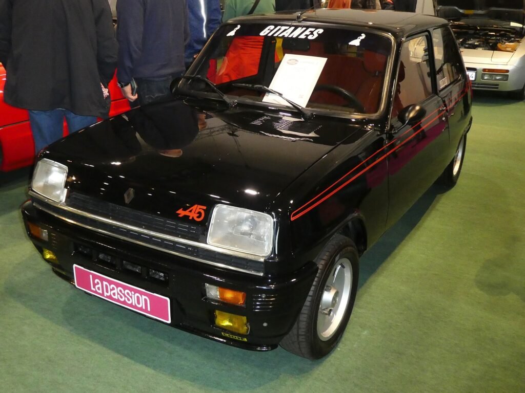 Black Renault 5 Alpine with red stripe at a classic car show