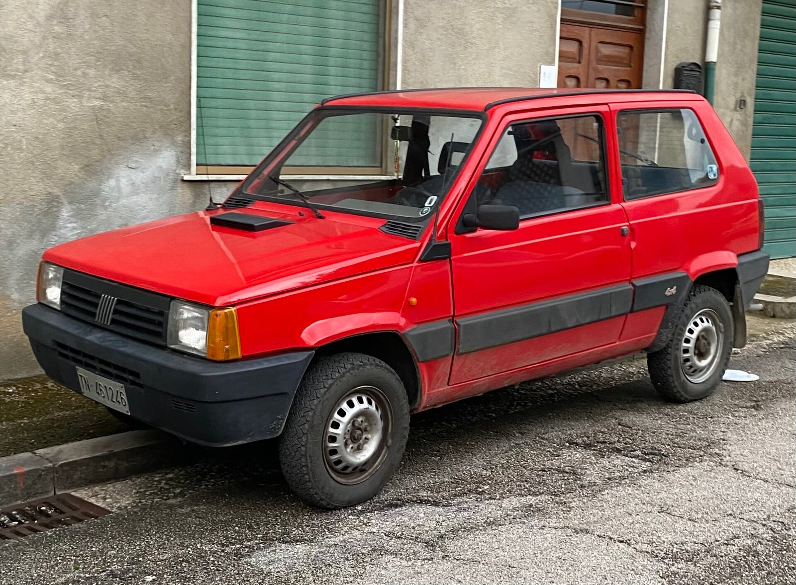 Fiat Panda 4x4 rossa parcheggiata in un paese di montagna
