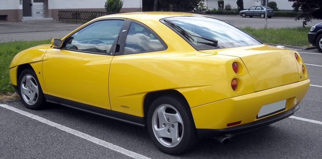 Posteriore di una Fiat Coupé gialla con i quattro fanali tondi incassati e la coda tronca