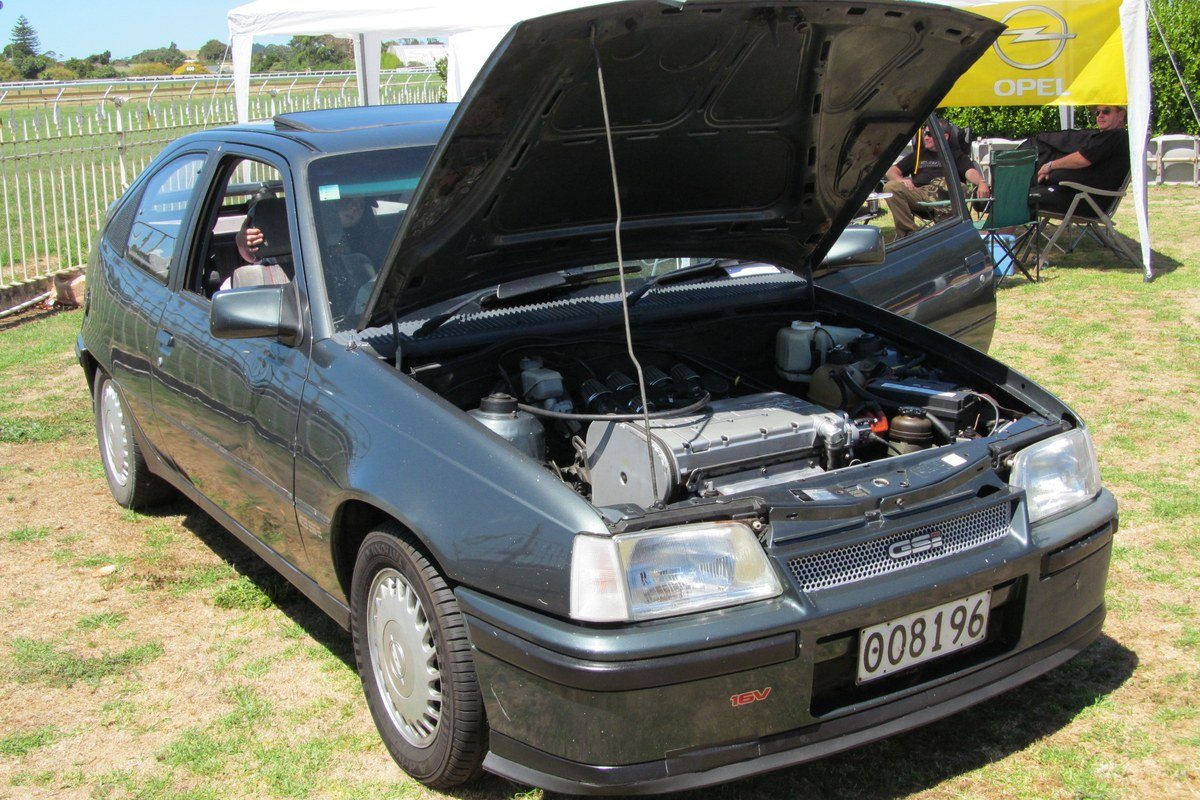 Opel Kadett GSi 16V gris de 1989 con el capó abierto y el motor de dieciséis válvulas a la vista