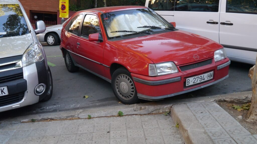 Opel Kadett GSi rosso con targa di Barcellona parcheggiato in strada