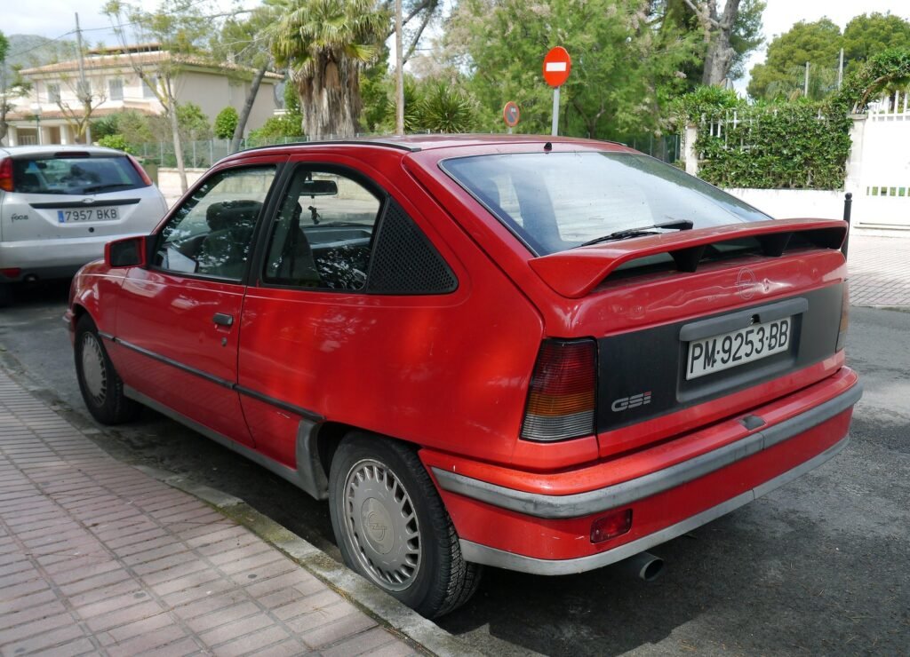 Opel Kadett GSi rojo con matrícula de Palma aparcado en Port d'Alcúdia, Mallorca