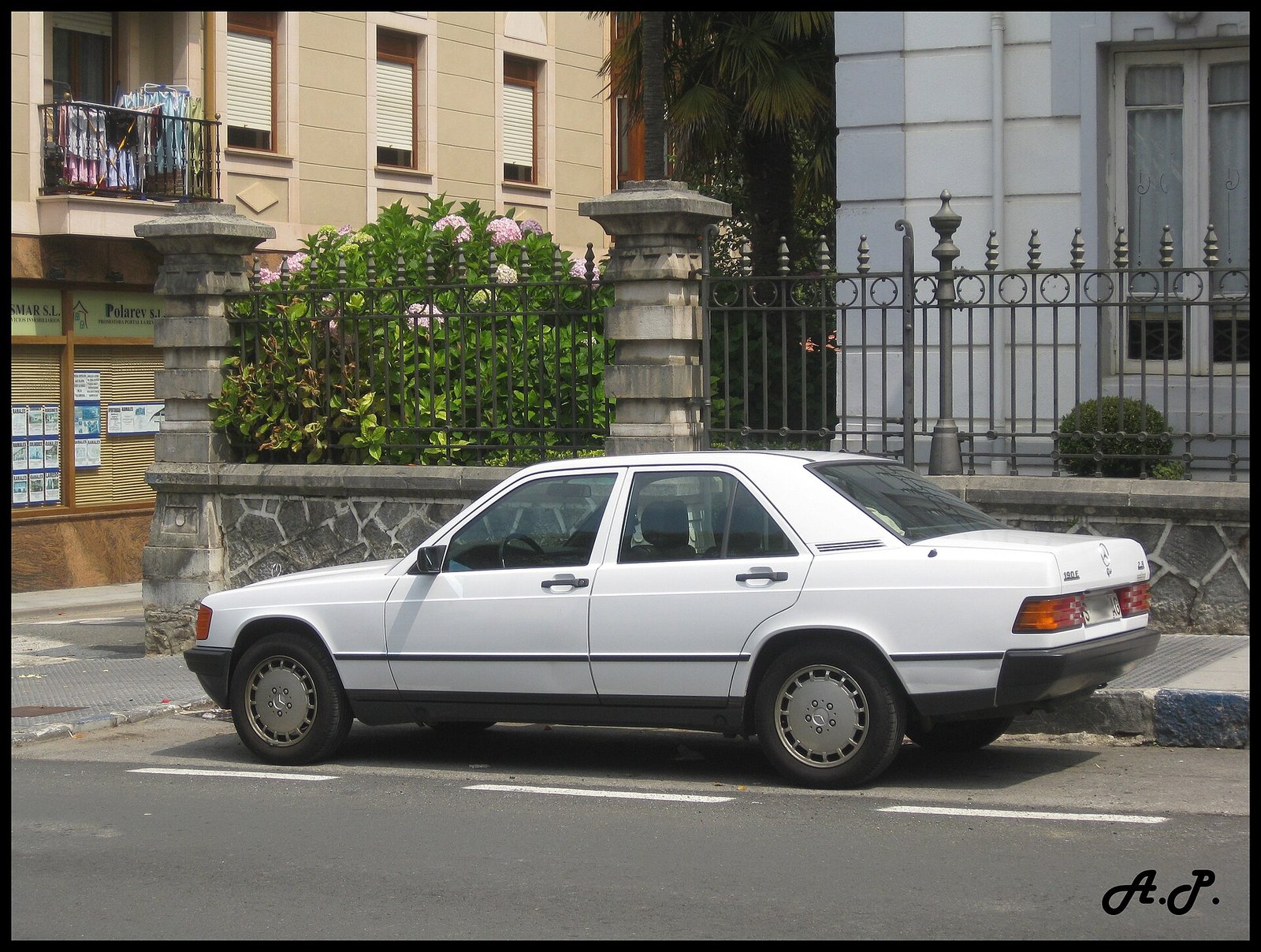 Mercedes-Benz 190 E bianca con targa di Santander parcheggiata in Cantabria, un'auto vecchia ancora in strada