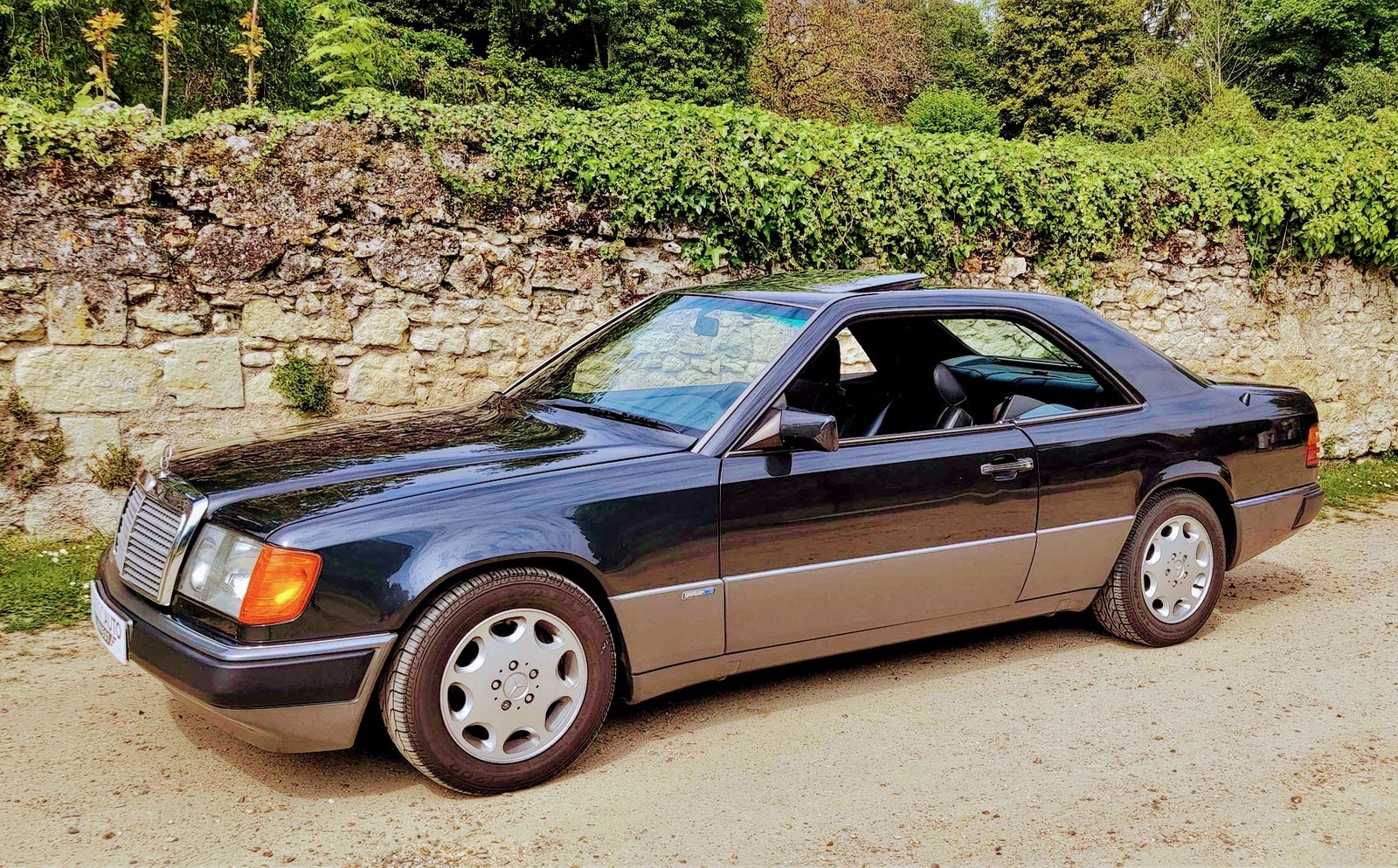 Mercedes 300 CE con i quattro finestrini abbassati, senza montante centrale
