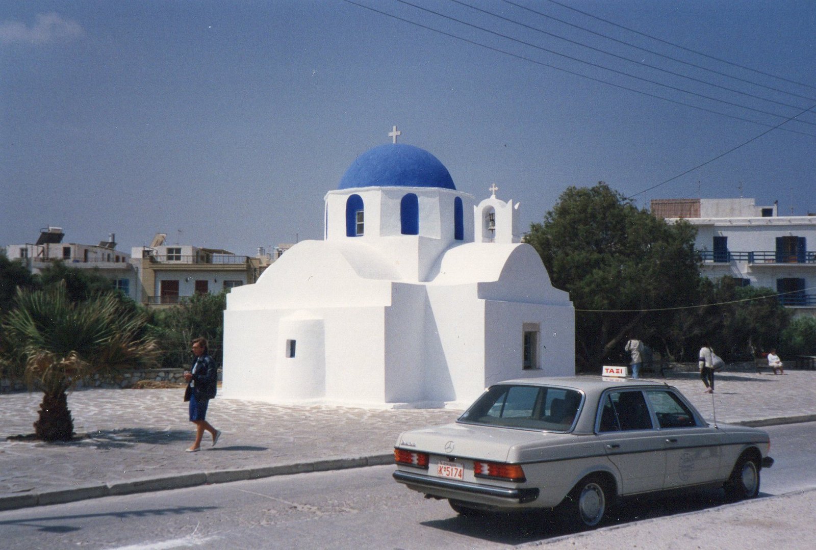 Taxi Mercedes-Benz 200 D W123 aparcado junto a una iglesia en Grecia