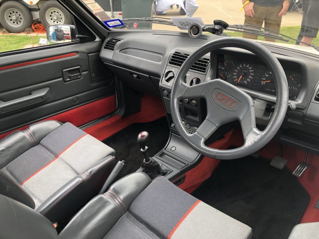 Interni della Peugeot 205 GTI con volante GTI e sedili con profili rossi